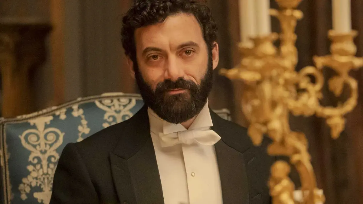 Morgan Spector sitting at a fancy table in The Gilded Age