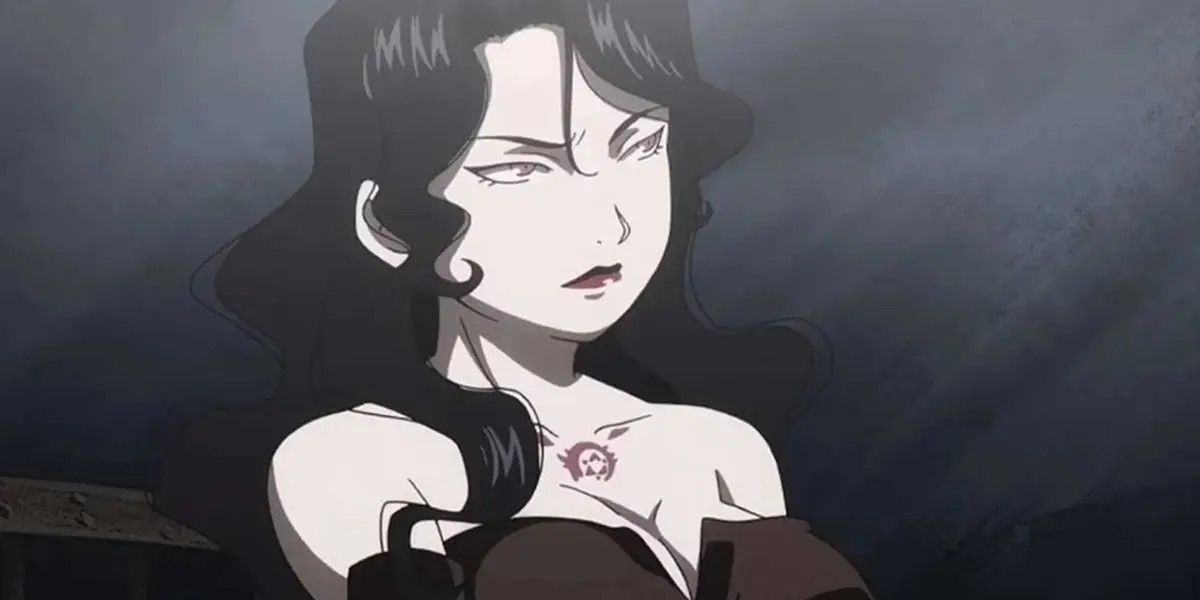 Lust makes a serious face in a dark room.