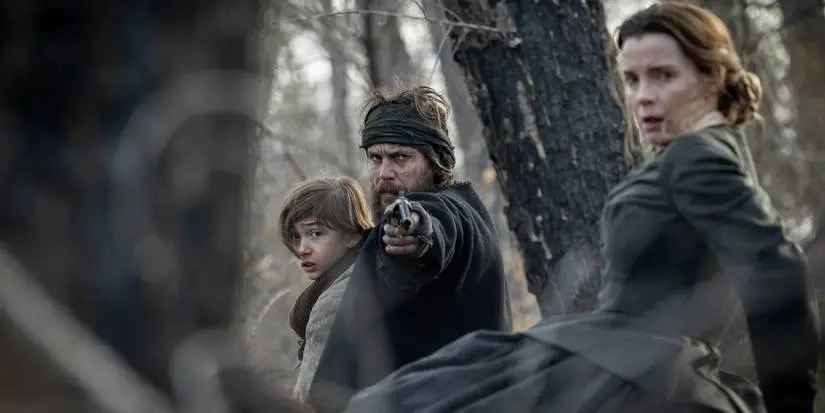Preston Mota as Devin Rowell, Taylor Kitsch as Isaac Reed, and Betty Gilpin as Sara Holloway in 'American Primeval.'