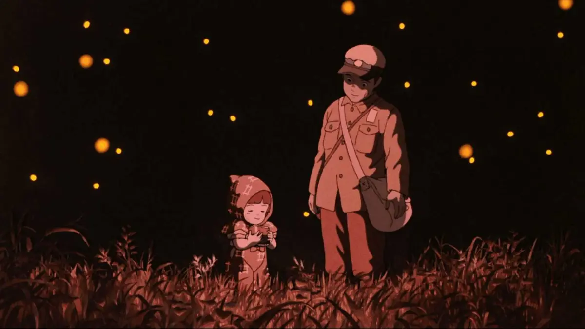 Seita and Setsuko under a sky filled with fireflies in Grave of the Fireflies.
