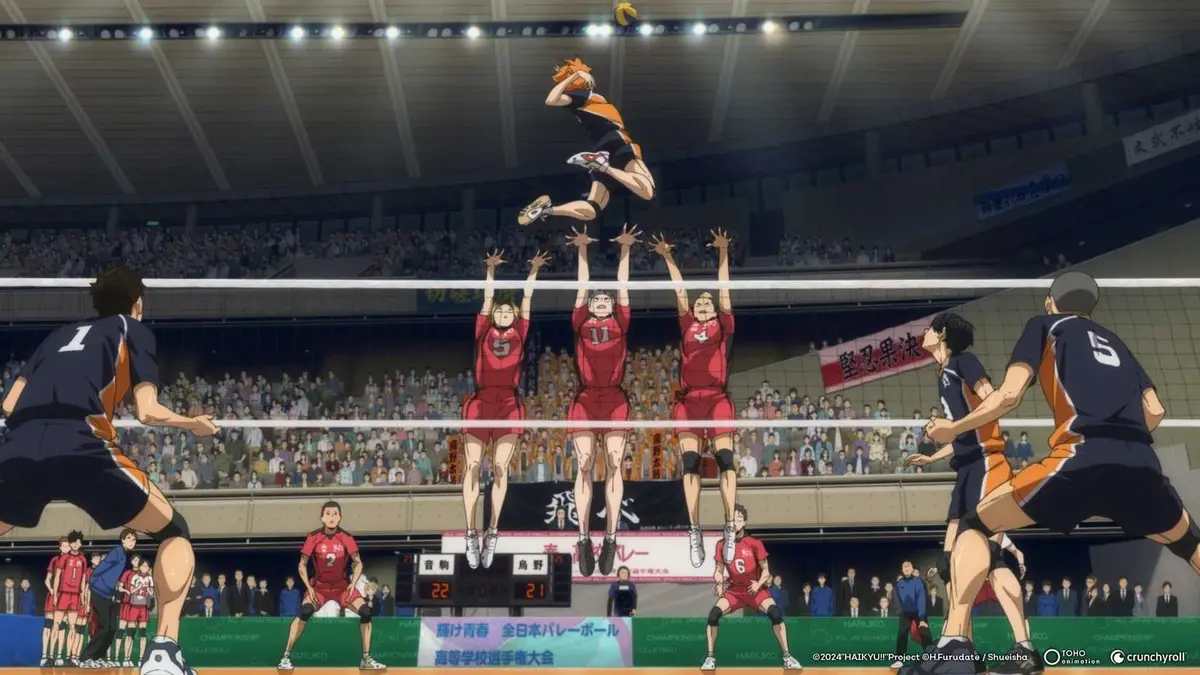 Hinata prepares for a spike as Nekoma players block him in Haikyu!! The Dumpster Battle.