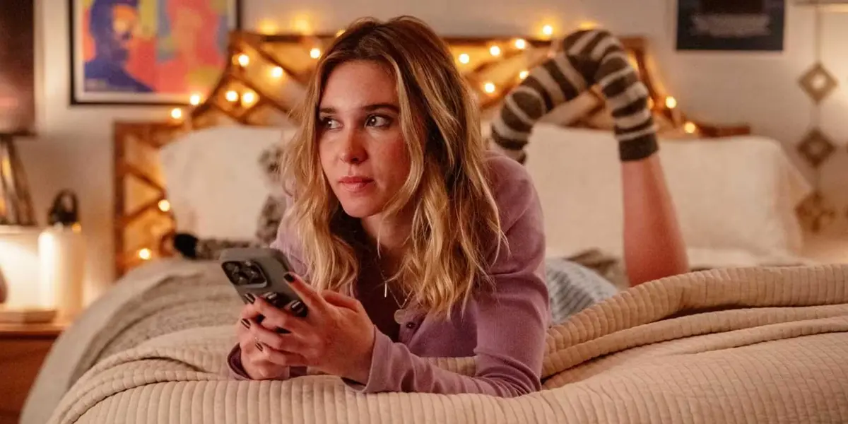 Tatum lays on her bed with her phone in her hand