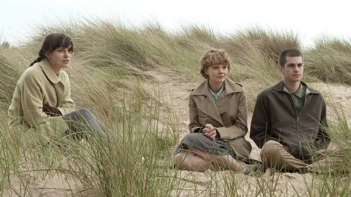 Kiera Knightly, Carrie Mulligan and Andrew Garfield sit on sand dunes in Never Let Me Go