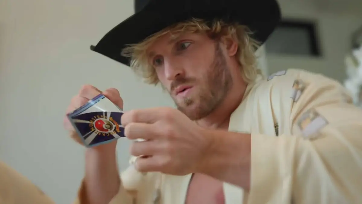 Logan Paul peels a CoroCoro Pokemon card carefully in a YouTube video.