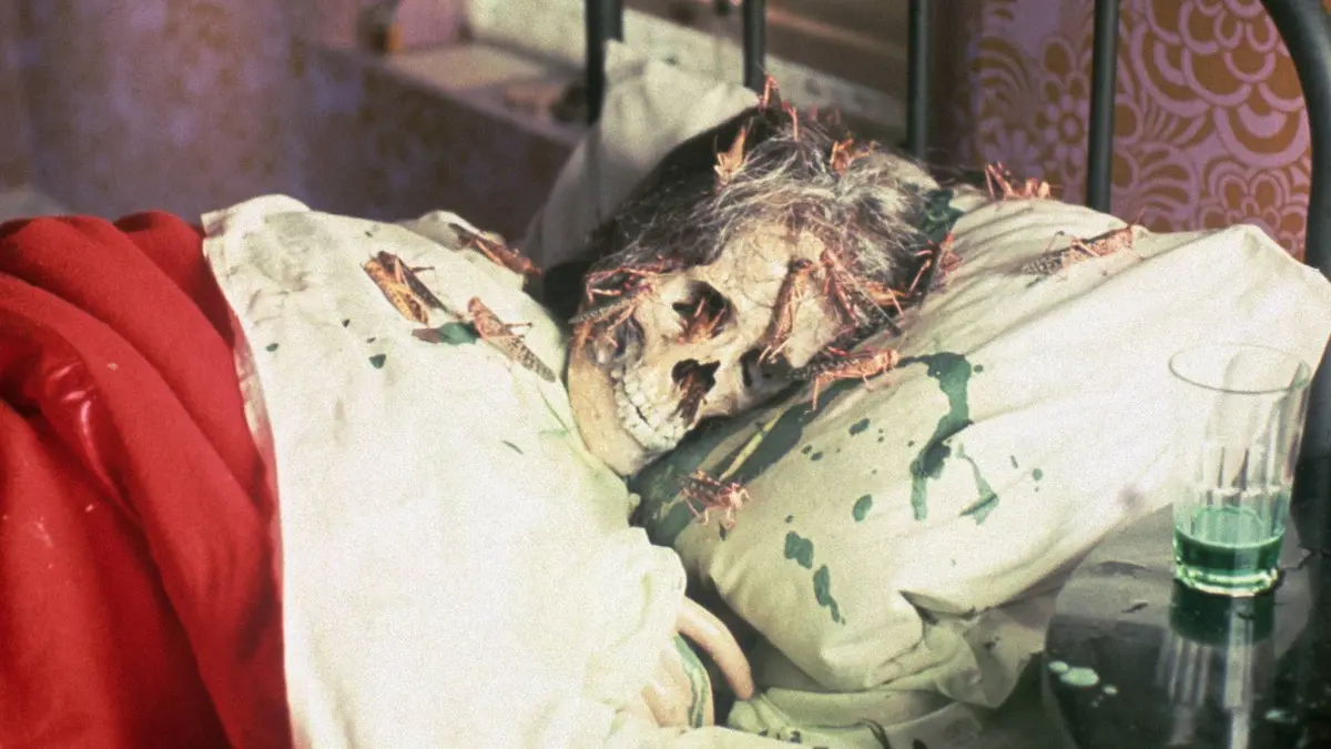 A skull covered in locusts lying in bed
