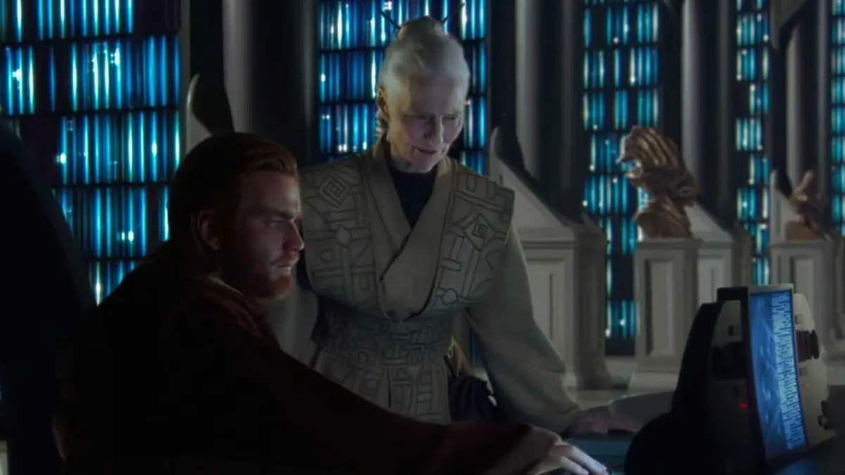 Jocasta Nu looks over a screen in Star Wars next to Obi Wan Kenobi.