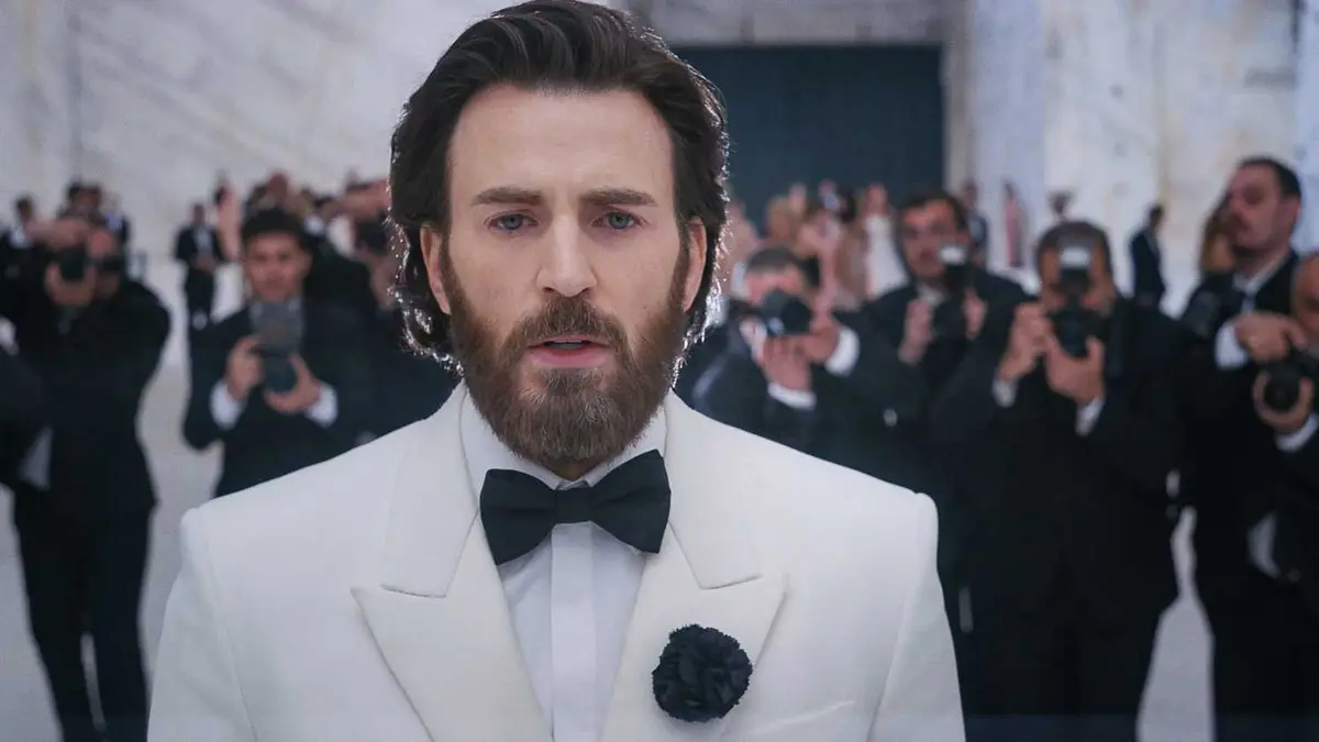 Chris Evans wearing a suit while photographers take his picture in Sacrifice