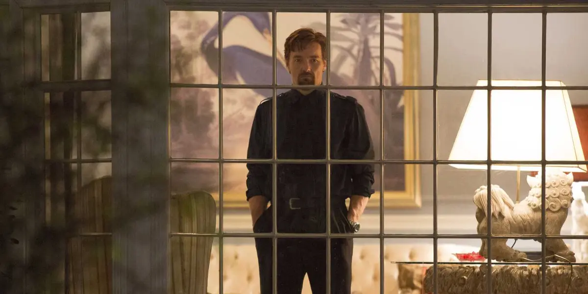 Joel Edgerton's Gordo stares angrily through a window in the 2015 horror movie The Gift