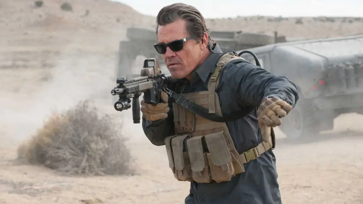 Josh Brolin's Matt aiming a rifle and putting his hand out to the side in Sicario: Day of the Soldado