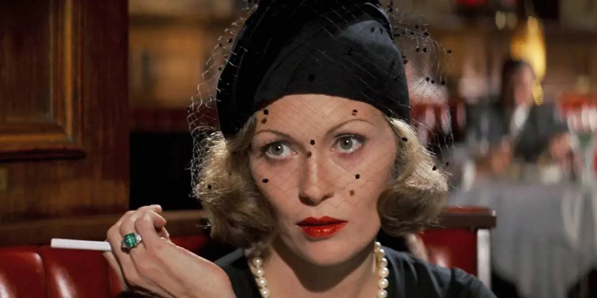 Faye Dunaway as Evelyn Cross smoking a cigarette in a restaurant in Chinatown