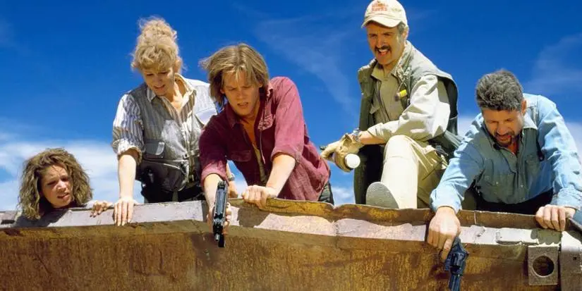The characters of Tremors (1990) pointing their guns at a threat