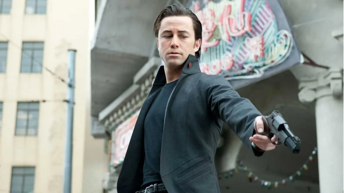 Joseph Gordon-Levitt holding a gun as Joe in Looper