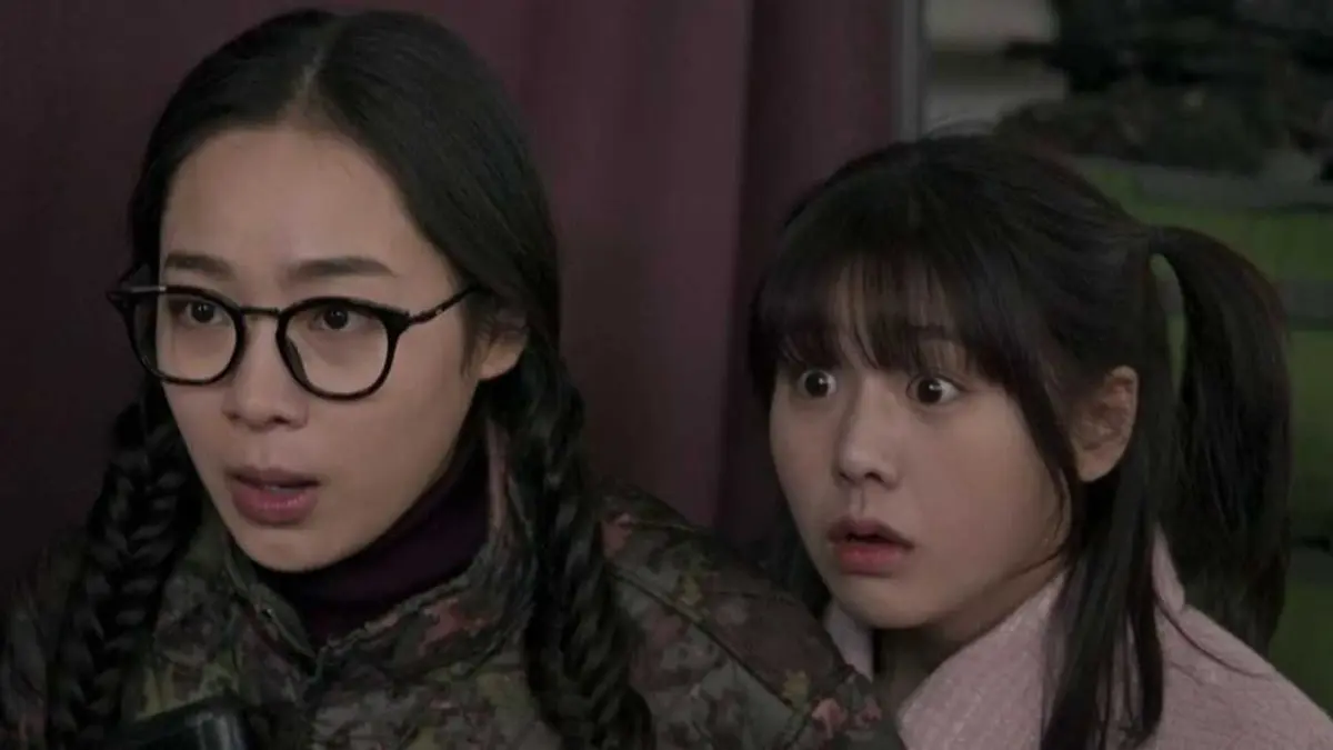Two teenage Korean girls are looking at something with shocked faces