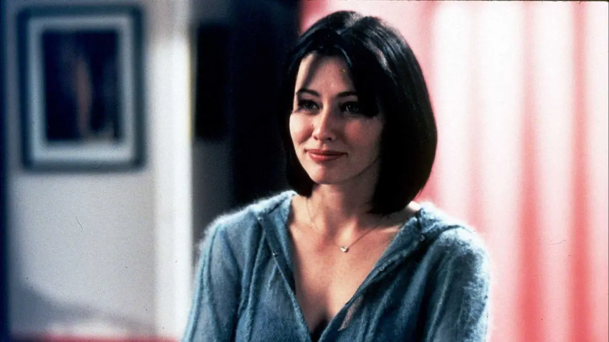 Shannen Doherty as Prue Halliwell smiling in Charmed.