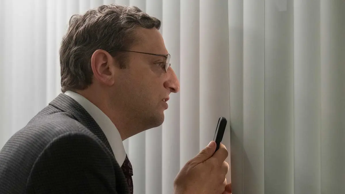 Tim Robinson peeking through blinds in the Chair Company