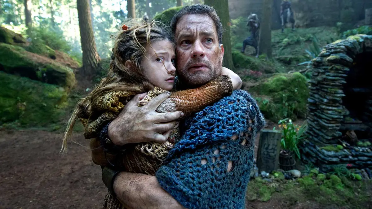 Cloud Atlas' Zachary holding a child and looking worried.