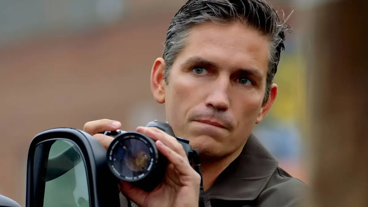 Jim Caviezel‘s John Reese holding up a camera in CBS’ Person of Interest