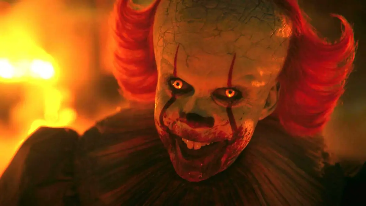 Bill Skarsgård's Pennywise smiling with his eyes glowing in IT: Welcome to Derry episode 7