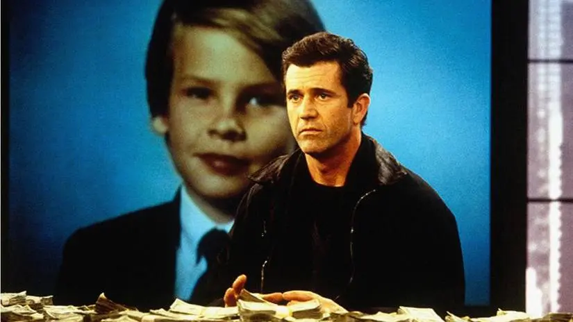 Tom Mullen sits in front of a picture of his son with a pile of cash on the table