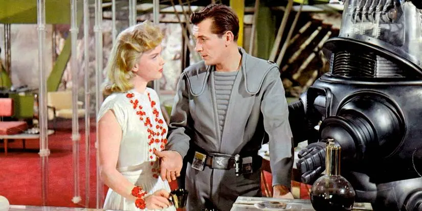 Alta Morbius and Commander John J. Adams stand next to the robot while talking and having coffee in Forbidden Planet