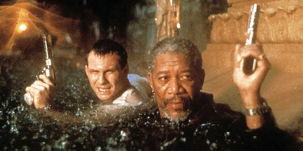 Christian Slater and Morgan Freeman hold guns up in a storm in Hard Rain