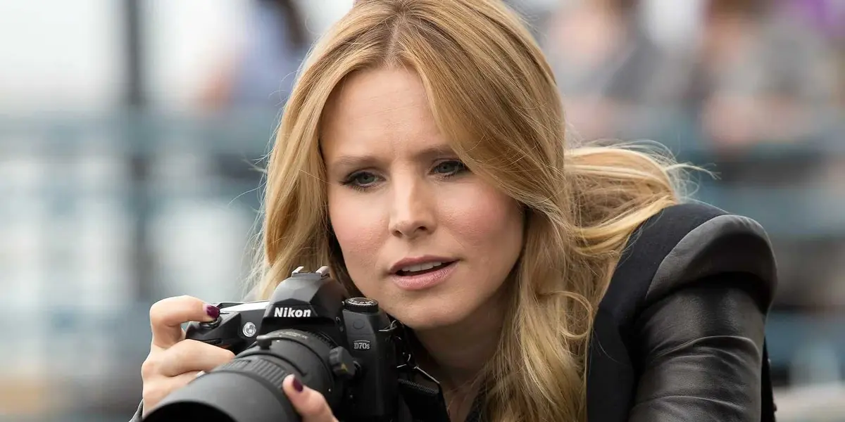 Veronica Mars holding a camera looking surprised