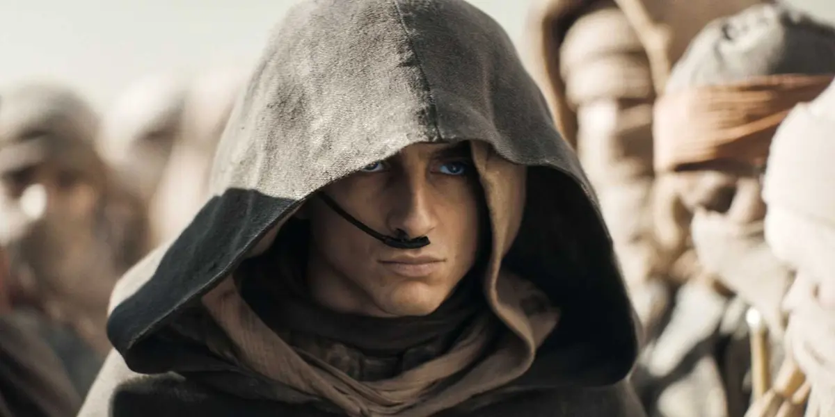 Hooded Paul surrounded by followers in Dune Part 2.
