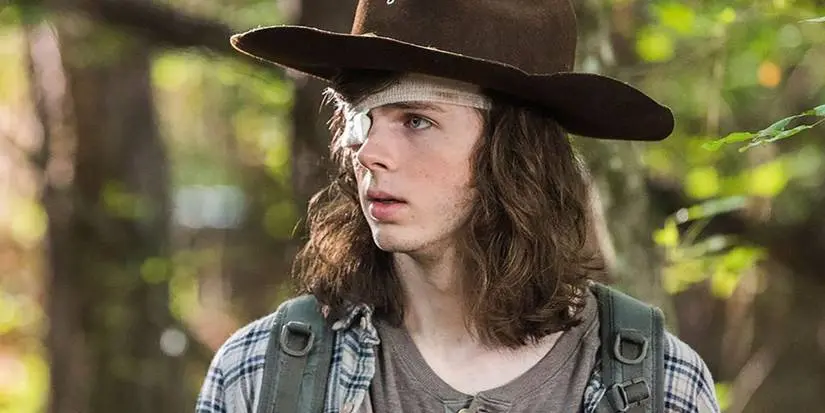 Carl Grimes walking in the woods in The Walking Dead
