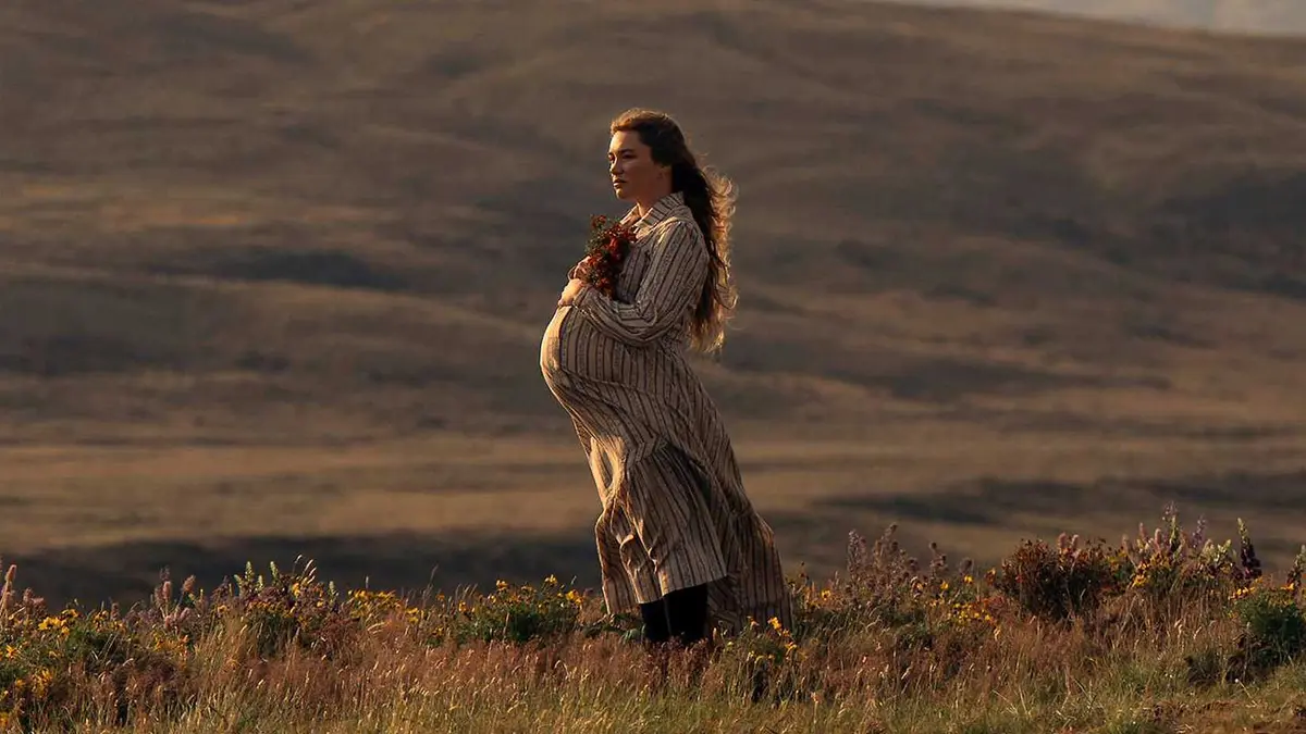 Cathy is pregnant and standing in nature in East of Eden.