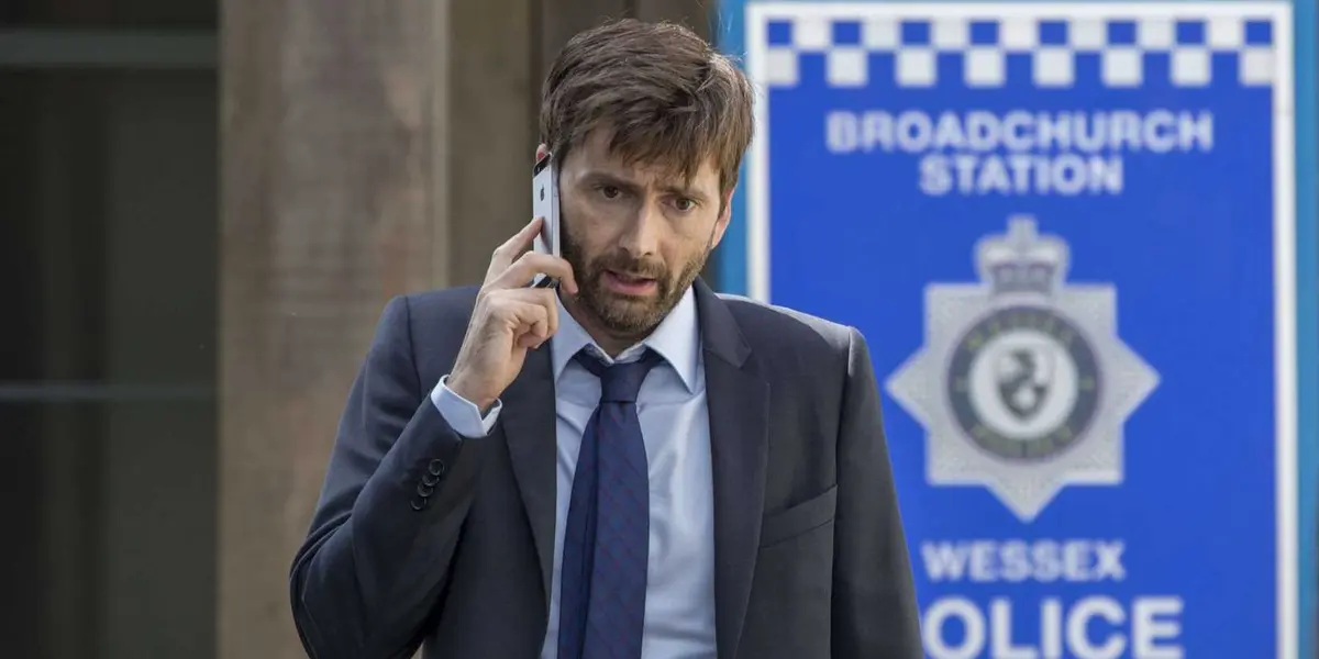 Alec Hardy (David Tennant on the phone looking stressed outside the police station in Broadchurch