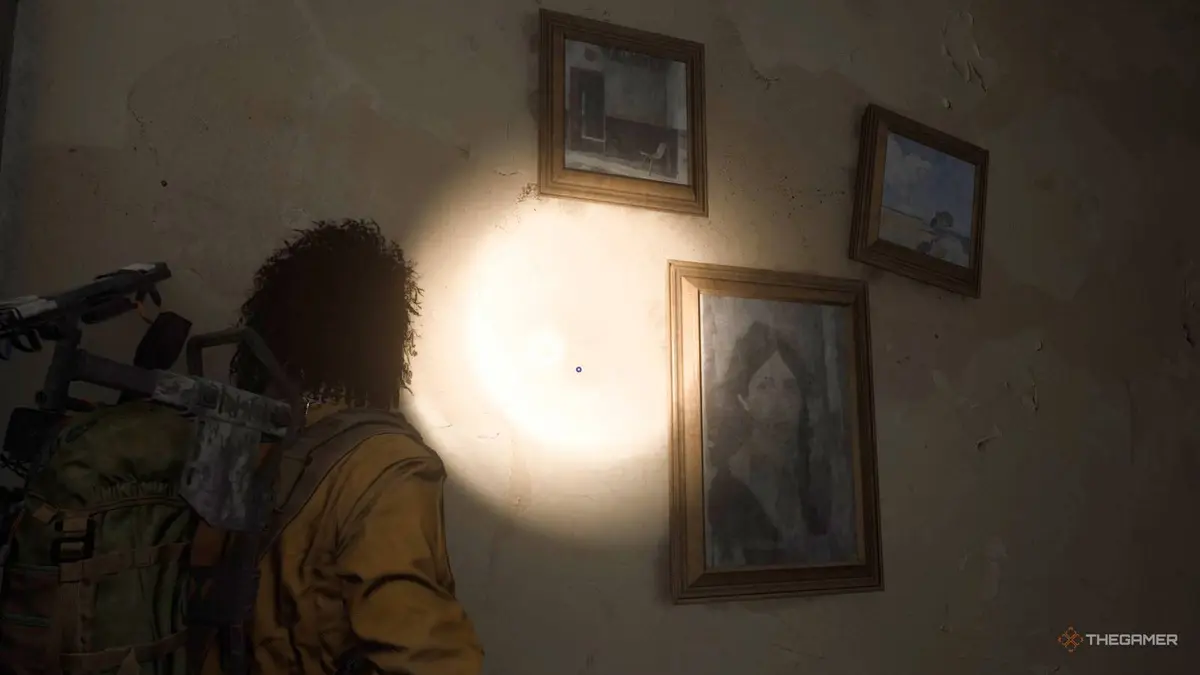 Player raider shining a flashlight on three portraits left in a pharmacist's apartment in Arc Raiders.