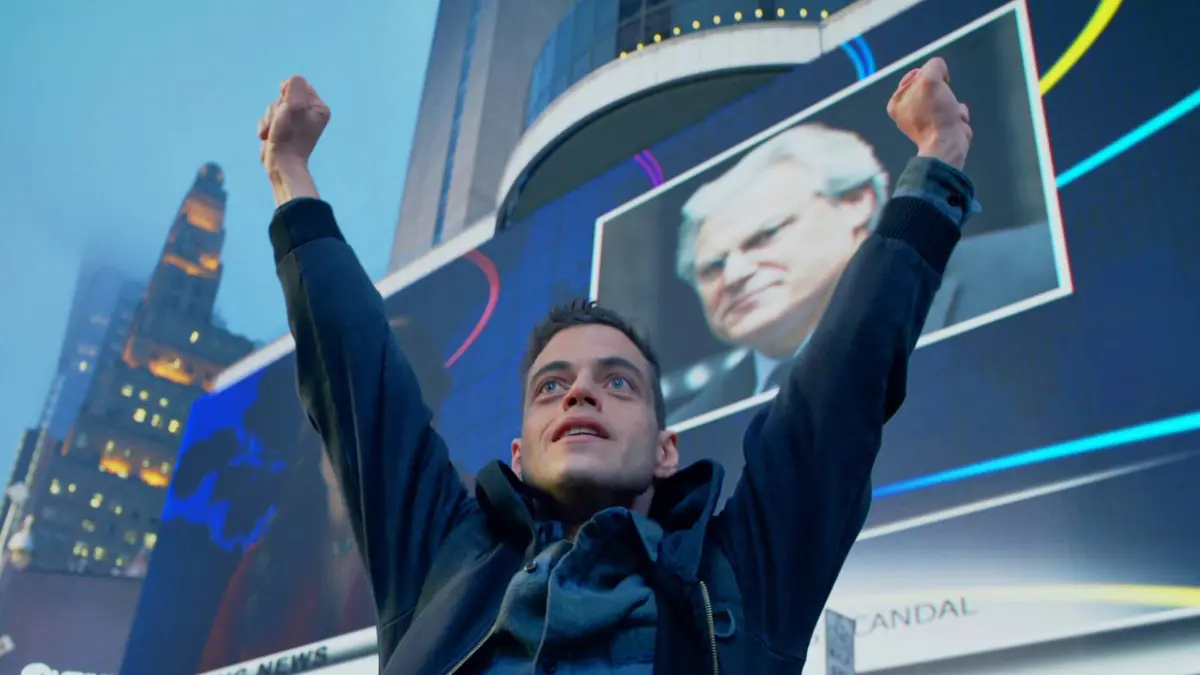 Rami Malek’s Elliot raising his hands in celebration in Mr. Robot