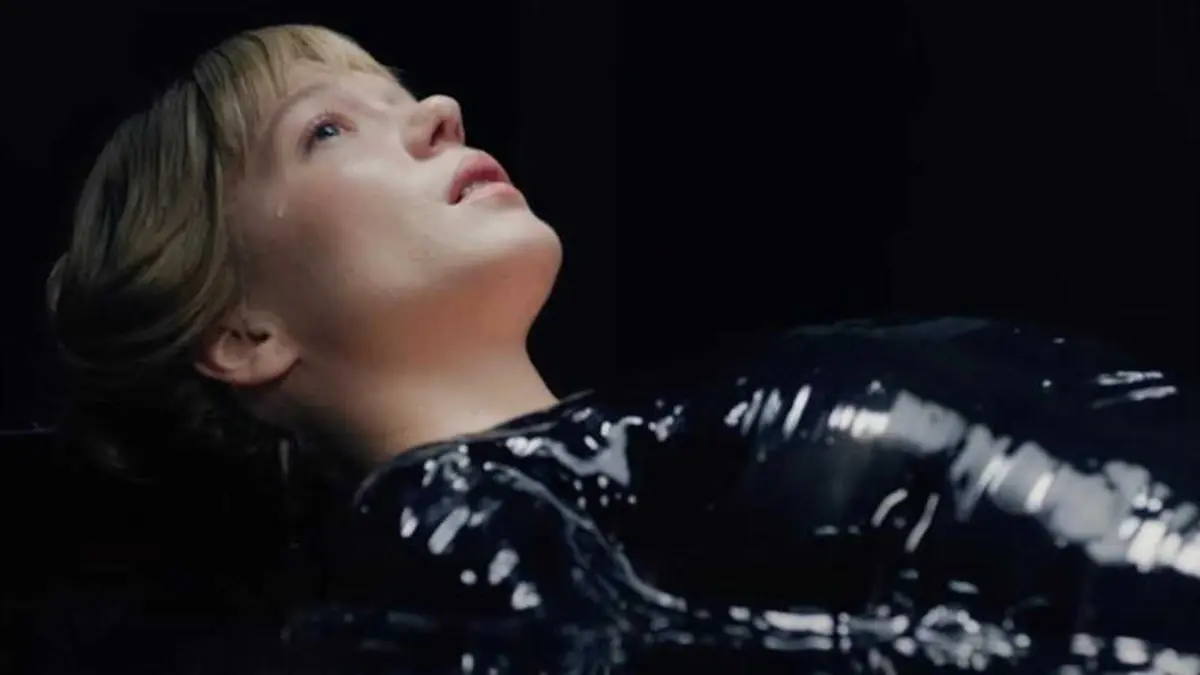 Lea Seydoux lays in a pod of black goo in The Beast