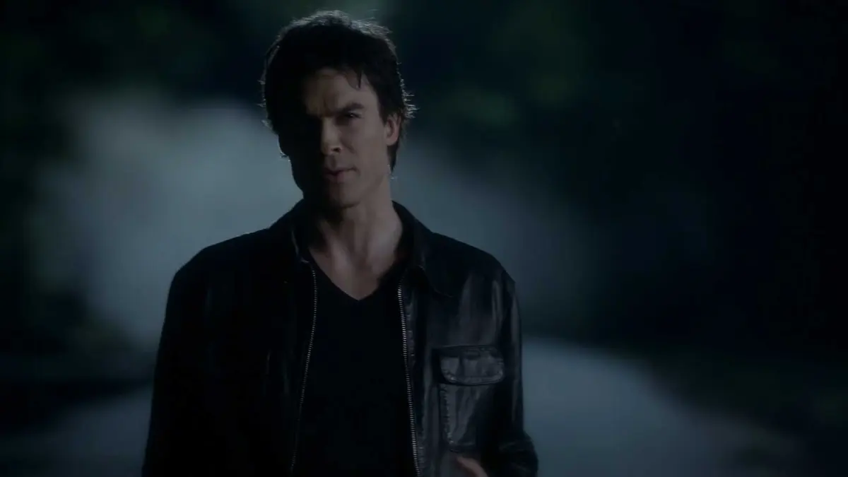 Damon stands in the middle of the road in Mystic Falls in The Vampire Diaries