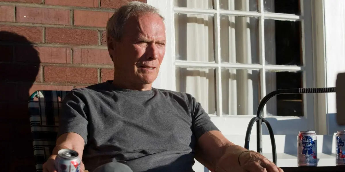 Clint Eastwood as Walt Kowalski sits on a porch in Gran Torino