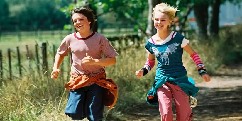 Blended image of Leslie (AnnaSophia Robb) and Jesse (Josh Hutcherson) excitedly running through a field in Bridge to Terabithia