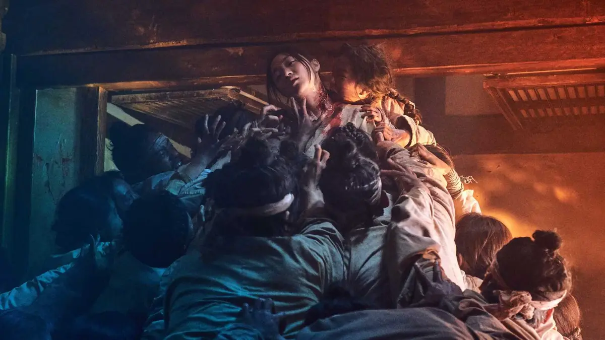 Zombies rapidly attacking a woman in Netflix's Kingdom series.