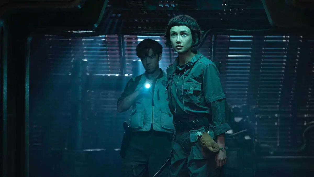 Wendy and Joe walking tentatively down a dark hallway in Alien: Earth
