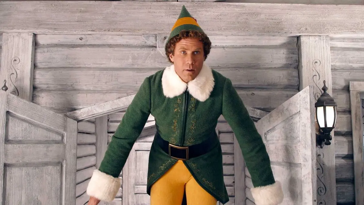 Buddy the Elf standing in front of a short door frame at the North Pole