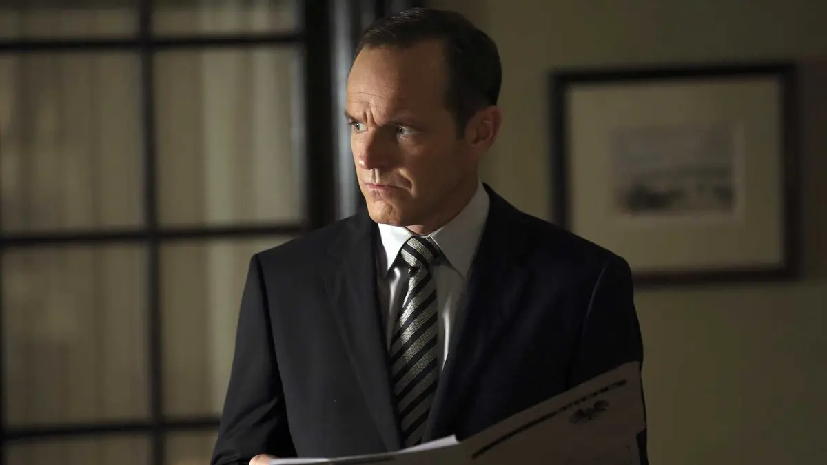 Clark Gregg as Phil Coulson holding a file while looking to the side in Marvel's Agents of SHIELD
