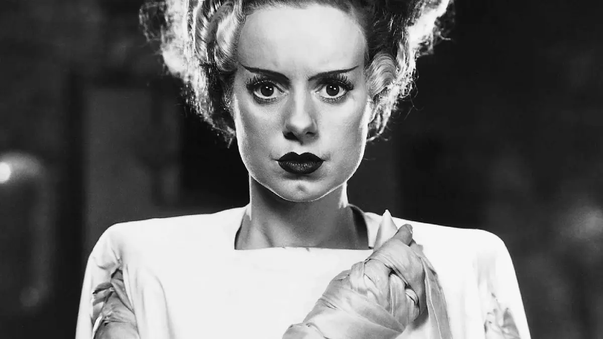 Elsa Lanchester as the bride of frankenstein clutching the sheets around her