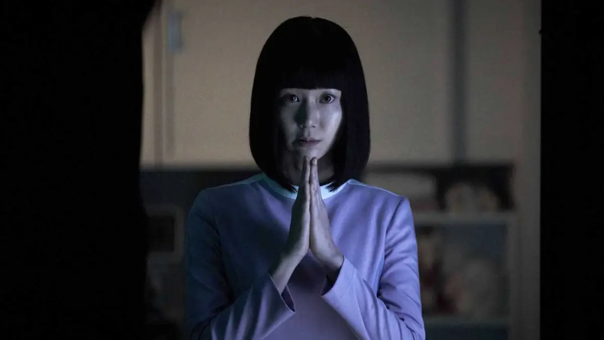 A woman with a black bob and purple shirt holds her hands in prayer in the sci-fi K-drama anthology series SF8.