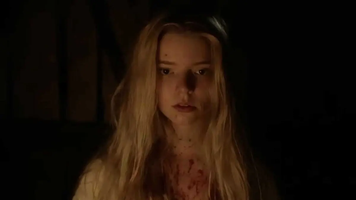 Anya Taylor-Joy as Thomasin  covered in blood talking to Black Phillip in The Witch