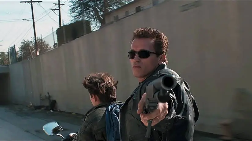 Arnold Schwarzenegger as the Terminator pointing a shotgun toward the camera in Terminator 2
