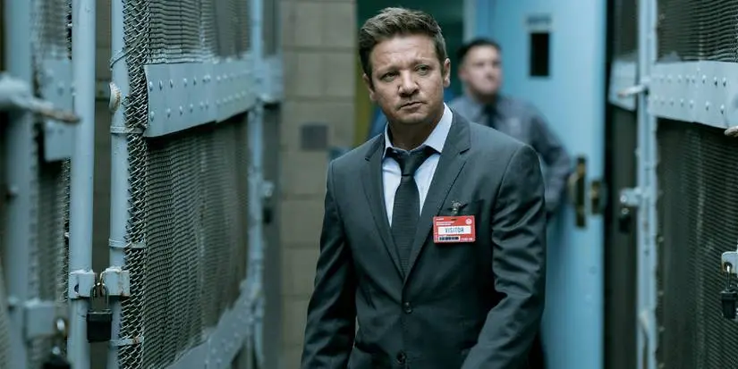 Mike McLusky (Jeremy Renner) walks into the prison while wearing a visitor pass in Mayor of Kingstown