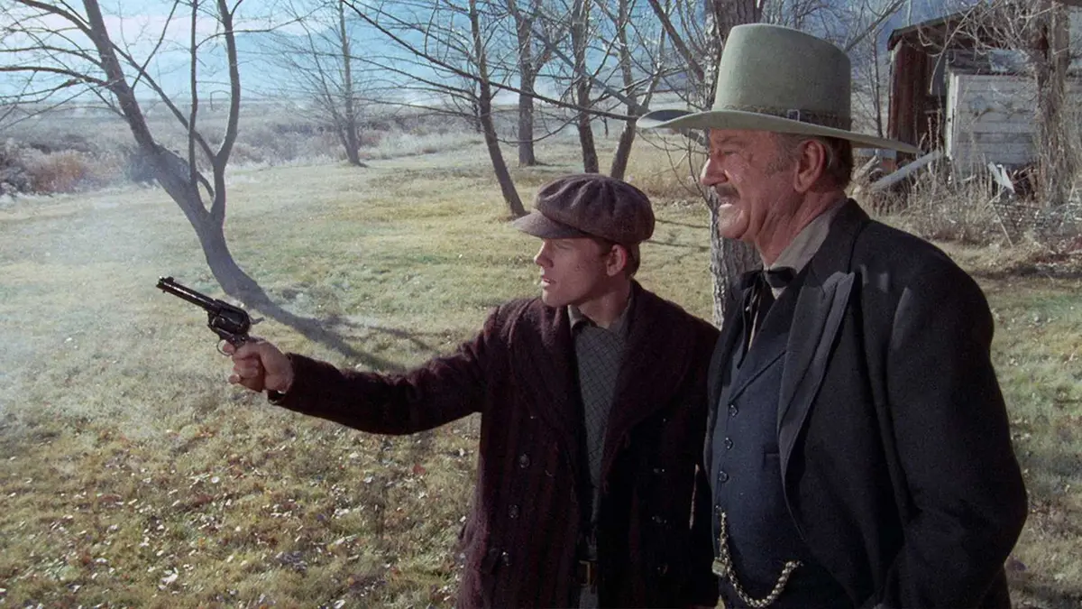 John Wayne and Ron Howard take a shooting lesson in The Shootist.