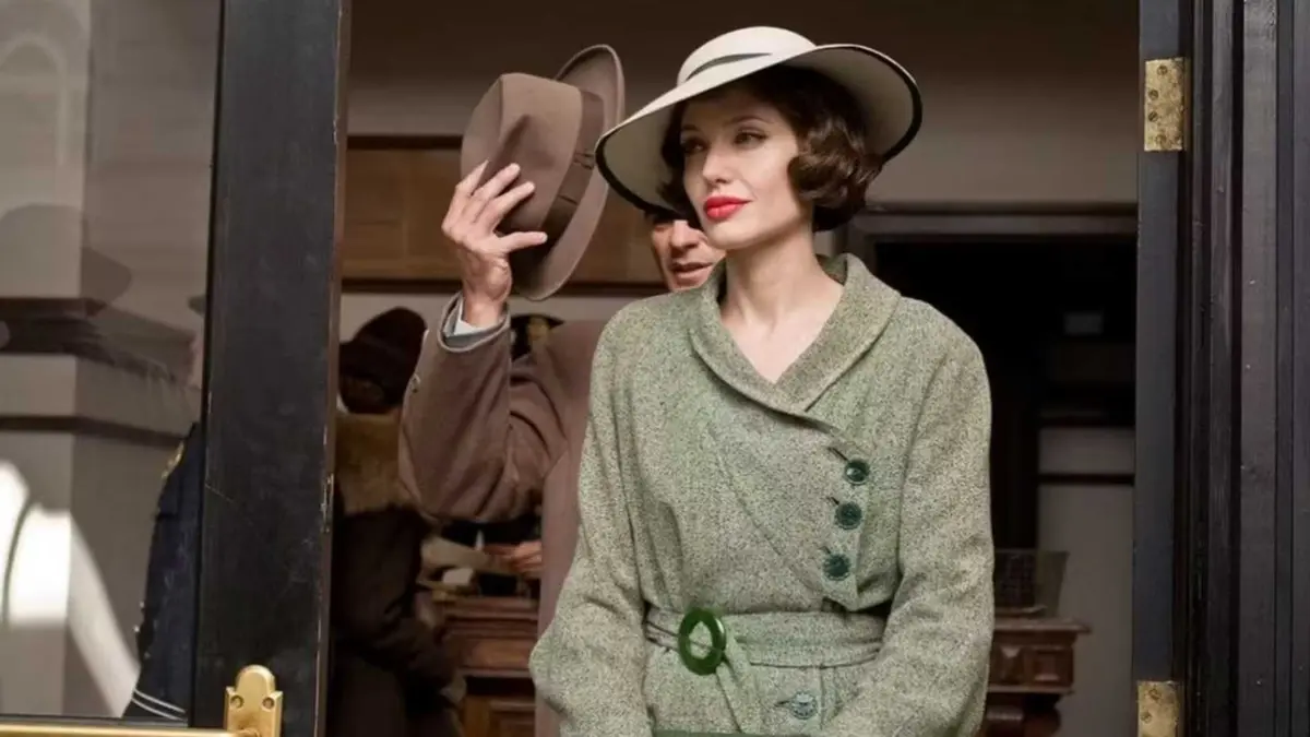 Angelina Jolie as Christine Collins smiling while exiting a building in Changeling