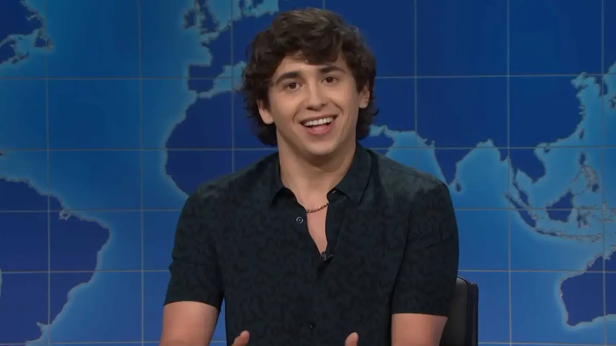 Marcello Hernandez smiling during the Weekend Update segment in Saturday Night Live.