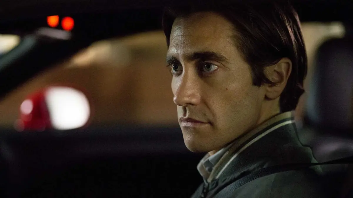 Jake Gyllenhaal sitting in a car as Louis Bloom in Nightcrawler