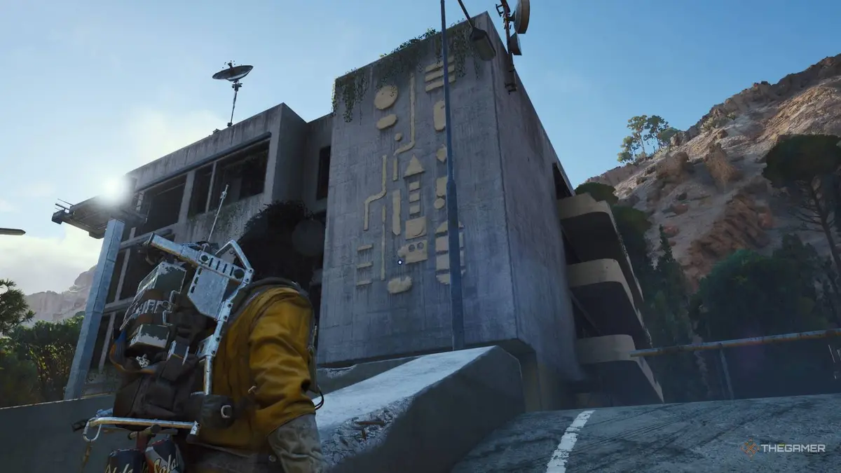 Player raider approaching the Pattern House, an apartment building with a yellow pattern along the wall, in Arc Raiders.